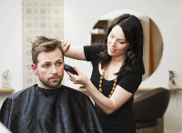 Frau schneidet Mann die Haare